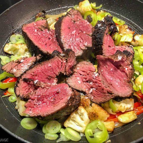 Beef tenderloin with mixed vegetables in a pan