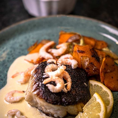 Fried cod with Sandefjord sauce Norwegian vegetables shrimps